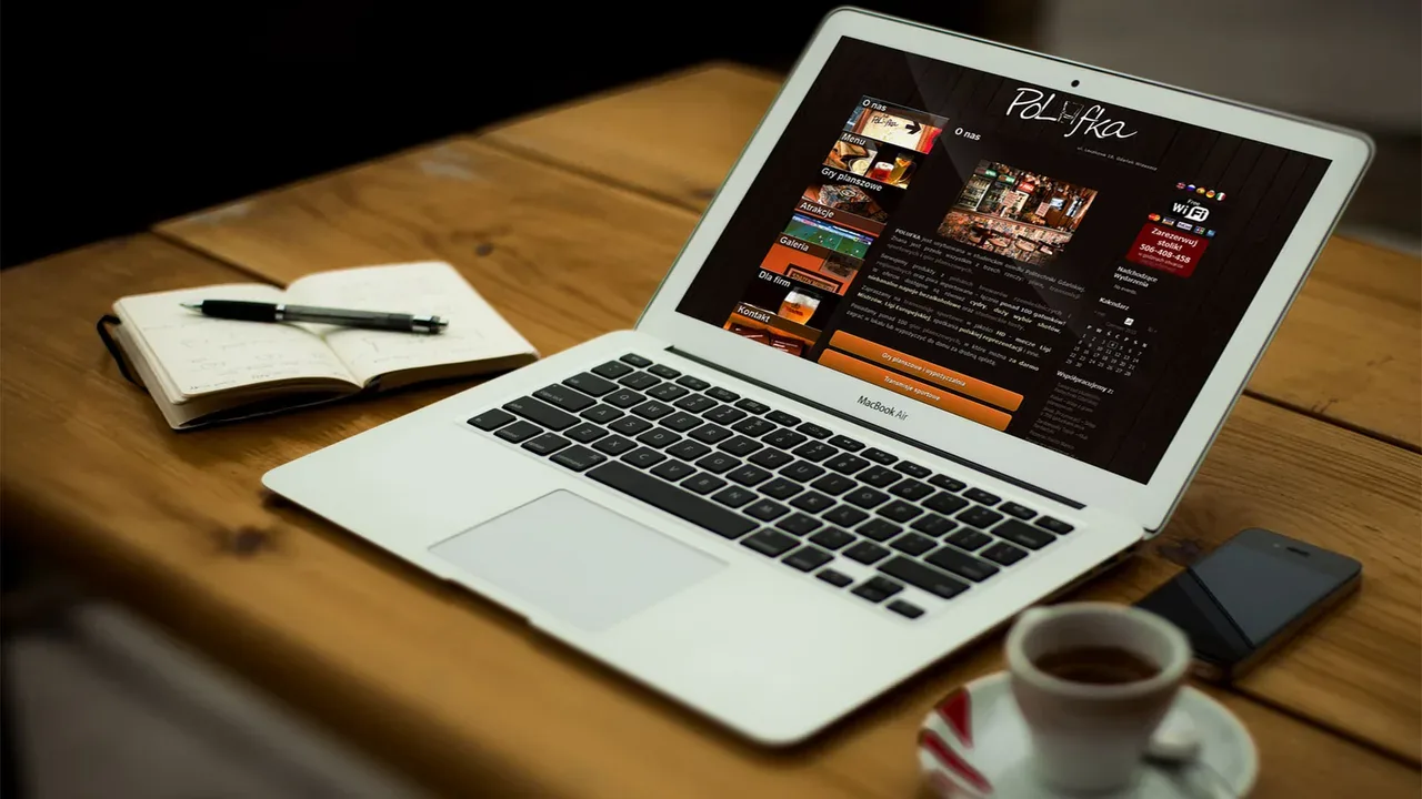 Polufka venue website on MacBook Air on wooden desk with coffee and notebook